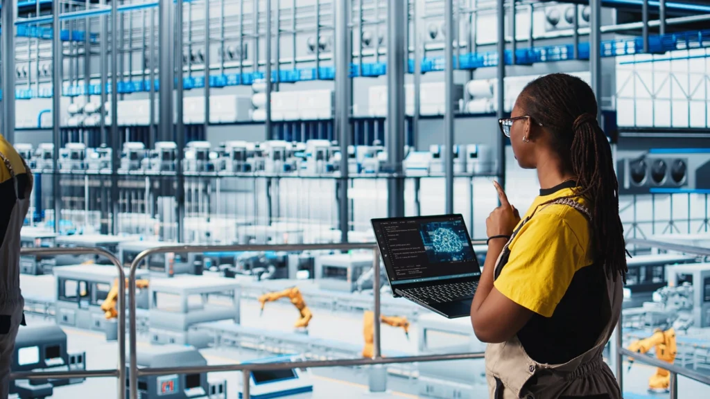 Chão de fábrica moderno da indústria 4.0 com operadores e tecnologias digitais integradas como IA e sensores industriais.