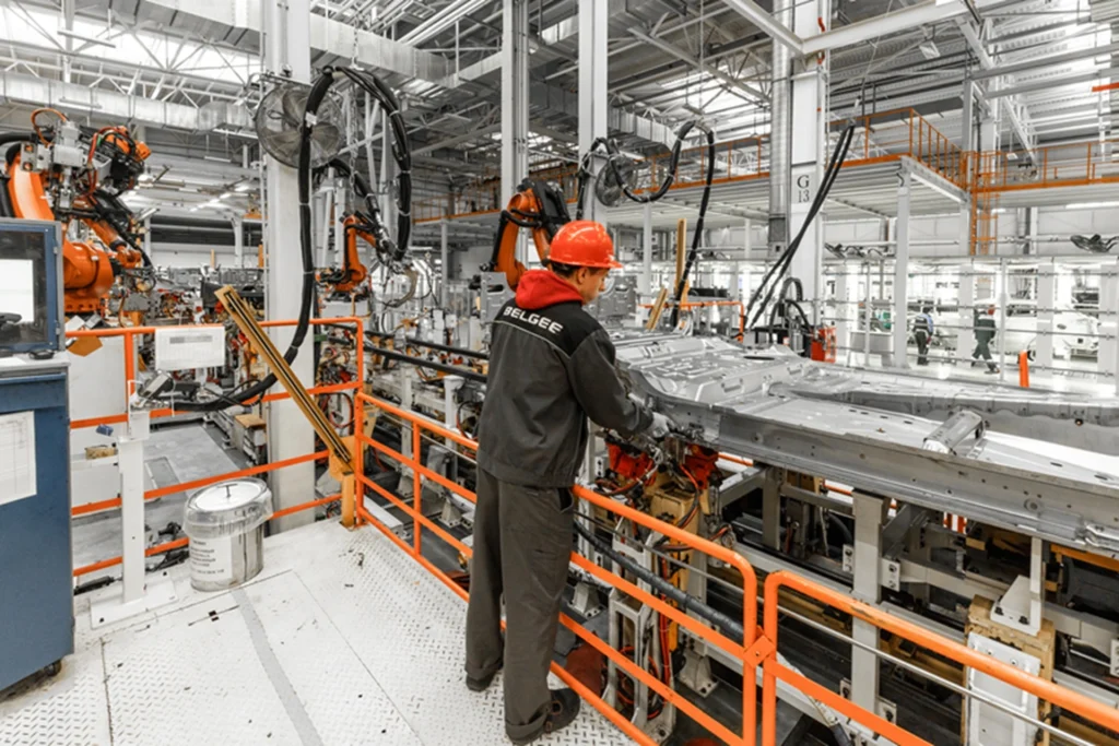 Trabalhador de empresas americanas operando uma linha de produção automotiva automatizada